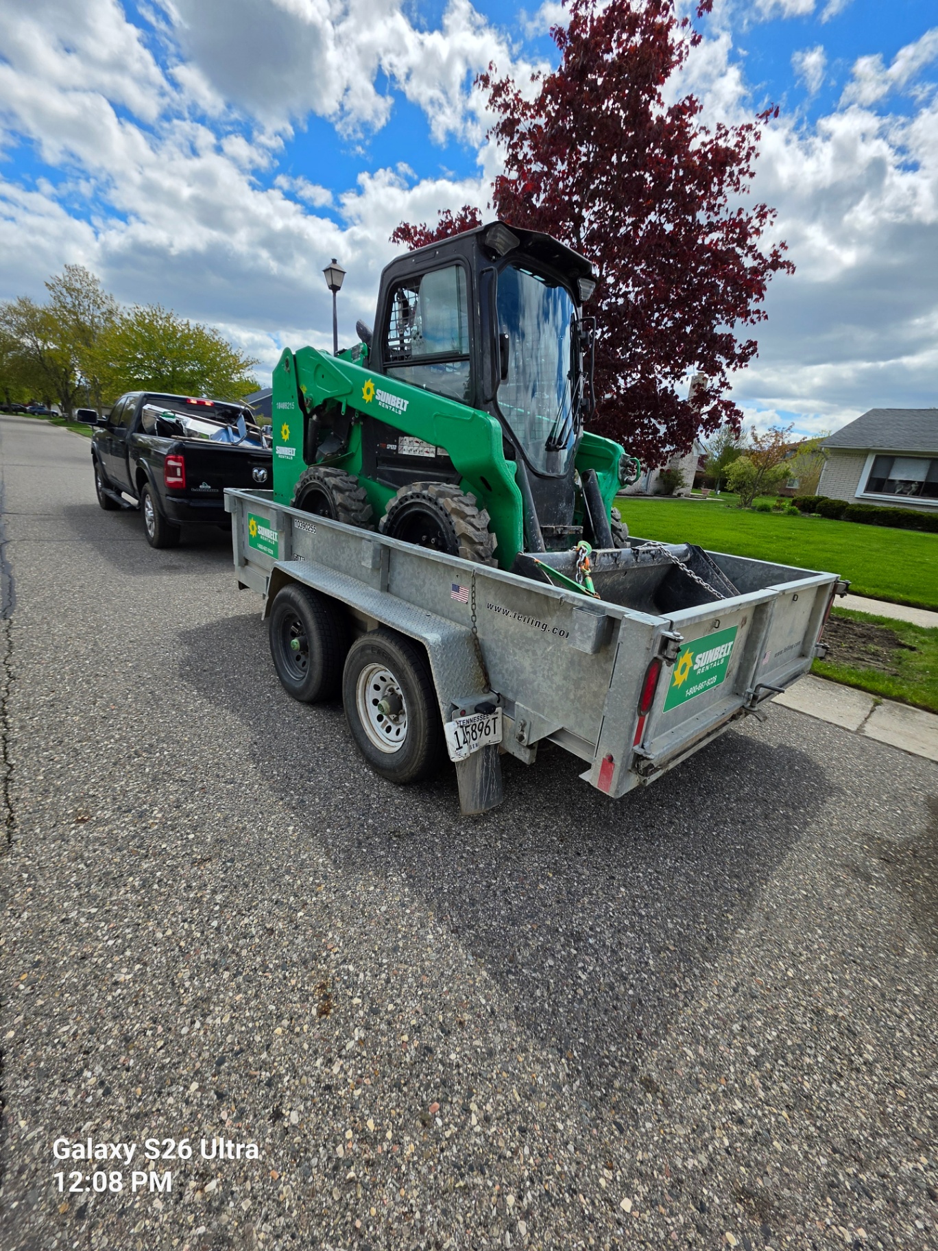 Skid steer equipment loaded on a trailer for landscaping work
